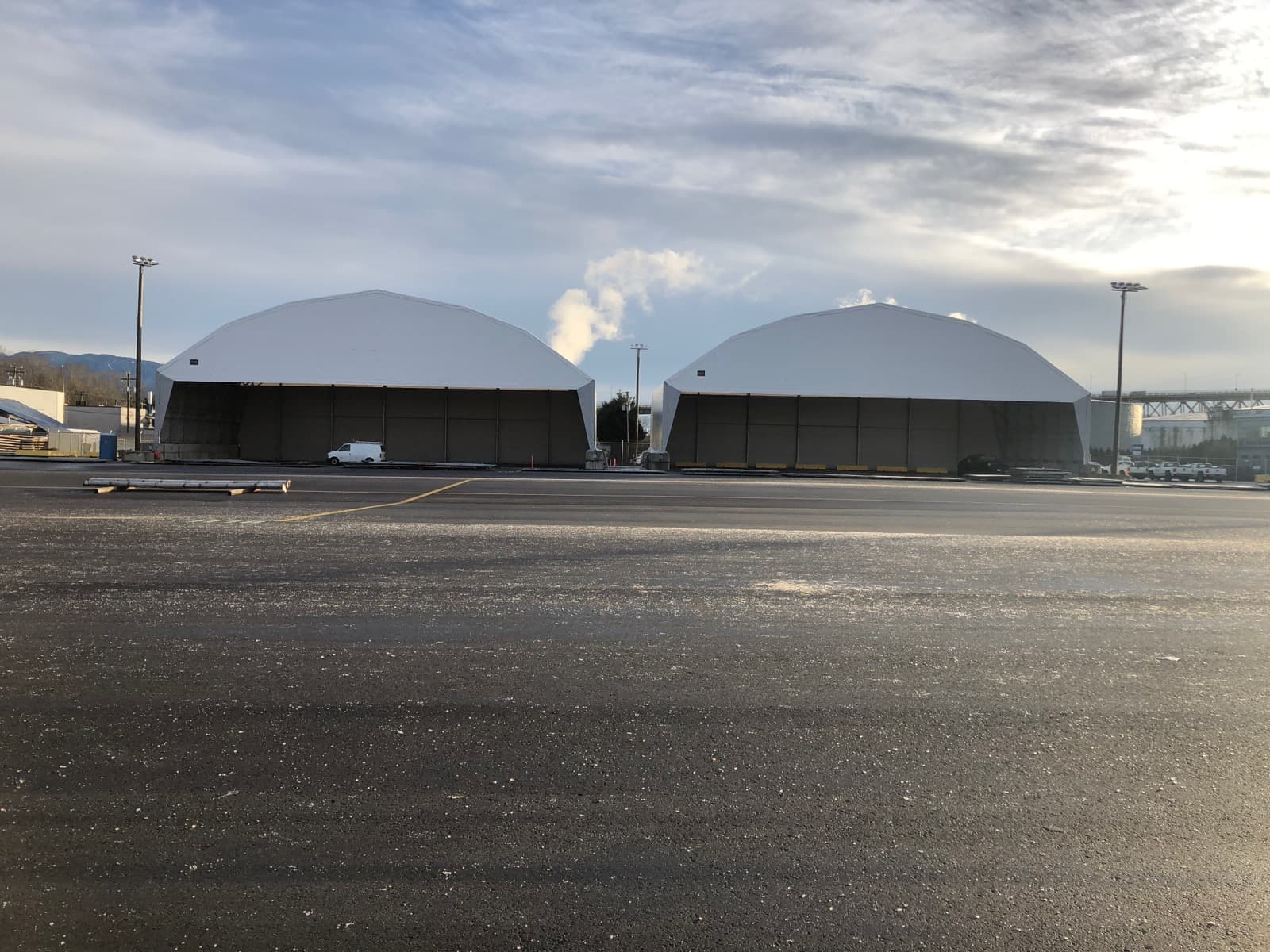 Two large fabric-covered structures providing industrial covered storage.
